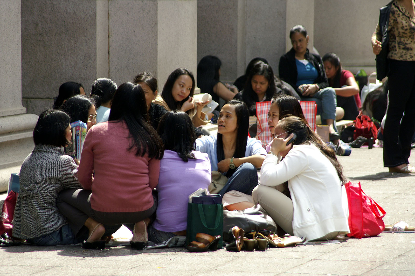 Filipina maids sitting in a circle outdoors