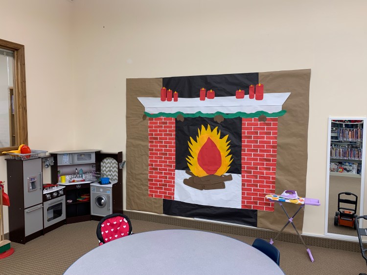 Fireplace made out of paper in the kids play corner of the library